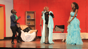 Cleante (Keith Muganza), Argan (Baguma Mathew) and Angelique (Rebecca Nalubowa) on stage in the singing scene in the Dynamo theatre production of Moliere's Imaginary Invalid