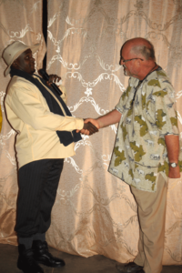Actor Bosco Sendawula playing Museveni meets Father Arnould de Schaetzen after the Dynamo performance of Loud Silence by George Ngobi